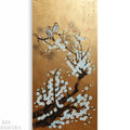 The image is a painting of two birds perched on a branch with white flowers. The background is a golden color
