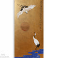The image is a painting featuring two cranes, one in flight and one standing on the water, with a large sun in the background. The painting has a golden background and is accompanied by Japanese text.